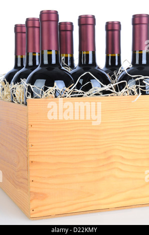 Il Cabernet Sauvignon bottiglie di vino in una cassa di legno. Formato verticale isolato su bianco con la riflessione. Foto Stock