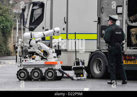 Belfast, Irlanda del Nord, Regno Unito. Il 12 gennaio 2013. PSNI officer sorge accanto a Northrop Grumman Archos telecomando senza equipaggio veicolo (robot) prima che esamina un dispositivo sospetto © Stephen Barnes / Alamy Live News esercito ATO ufficiali erano chiamati a rendere sicuro il dispositivo che è stato tenuto lontano per esame forense. La scena è stata dichiarata sicura, le strade sono state riaperte e i residenti sono stati autorizzati a tornare alle loro case. Credito: Stephen Barnes / Alamy Live News Foto Stock