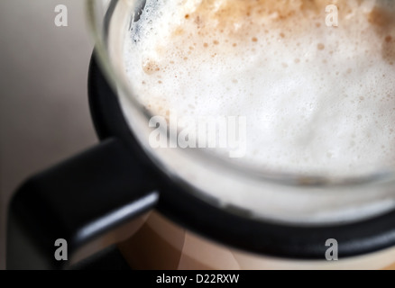 Closeup colpo di schiuma di latte sul cappuccino in tazza di vetro Foto Stock