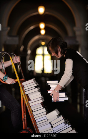 Gli organizzatori del Festival manovrare una pila di libri su un carrello per sacchi a Cheltenham Festival della Letteratura REGNO UNITO Foto Stock