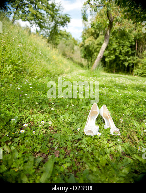 Una coppia di bianco scarpe matrimonio sull'erba Foto Stock