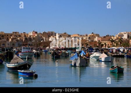 Il pittoresco paesaggio di numerose attività di pesca tradizionale barche nel porto di Marsaxlokk, Malta Foto Stock