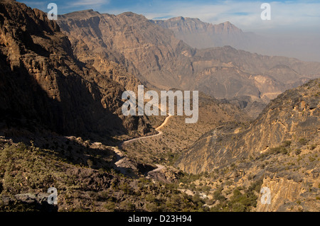 Strada sconnessa dal passo Sharaf al Alamayn attraverso il Al montagne Hajar all'oasi Haat, Sultanato di Oman Foto Stock