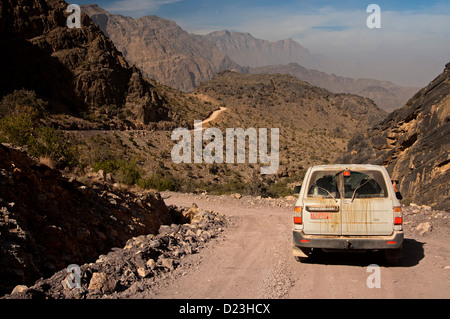 Strada sconnessa dal passo Sharaf al Alamayn attraverso il selvaggio paesaggio montuoso alle oasi Haat, Sultanato di Oman Foto Stock