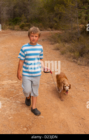 Un 8 anno vecchio ragazzo di camminare un cocker spaniel cane in Spagna Foto Stock