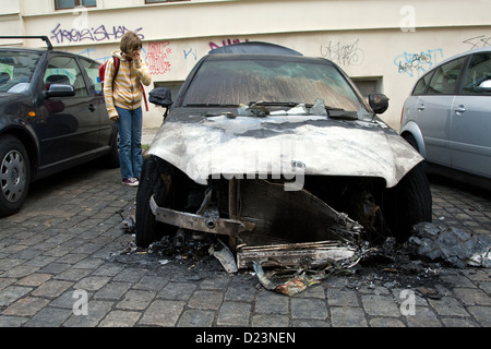 Berlino, Germania, ragazza guarda un'auto bruciata in Berlin-Mitte Foto Stock