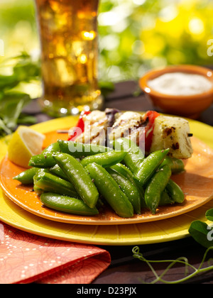 Scatto di zucchero piselli servita con tofu e un ice tea in un dehor estivo impostazione Foto Stock