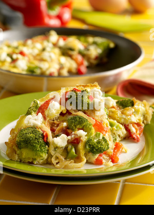 Cipolle caramellate, peperone rosso, broccoli e formaggio frittata in una impostazione di cucina Foto Stock