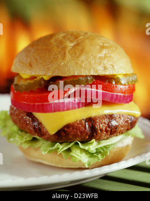 Grigliata di cheeseburger con barbecue fiamme in background Foto Stock