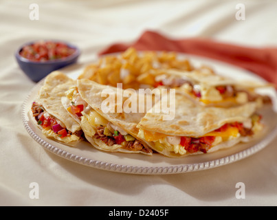 Una colazione quesadilla ripieno con uova, pancetta, pomodori e formaggio fuso servito con patate e salsa Foto Stock