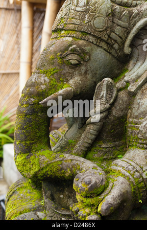 Ganesh in pietra con moss crescente sul suo volto a Bali Foto Stock