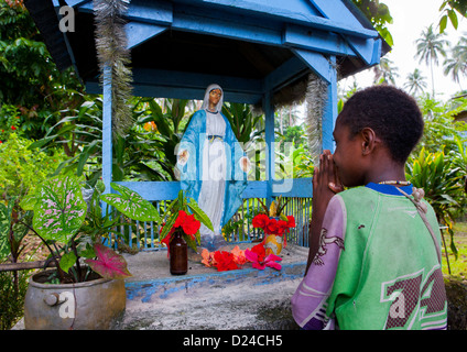 Youg Girl pregando davanti della Vergine Maria statua, Nuova Irlanda Isola, Langania Village, Papua Nuova Guinea Foto Stock