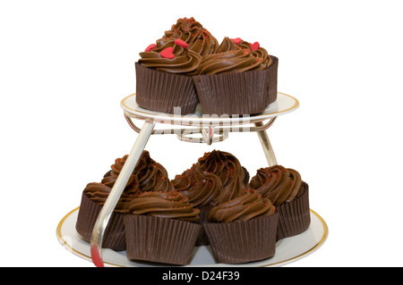 Crema di cioccolato tortine su una torta Stand con Amore Rosso cuore dolci Fuoco selettivo Foto Stock