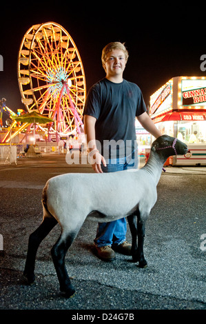 Ragazzo con una pecora e il parco dei divertimenti di corse al Maryland State Fair, Timonium MD Foto Stock