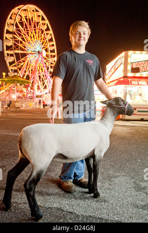 Ragazzo con una pecora e il parco dei divertimenti di corse al Maryland State Fair, Timonium MD Foto Stock