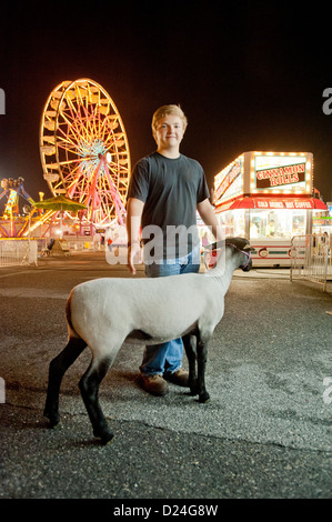 Ragazzo con una pecora e il parco dei divertimenti di corse al Maryland State Fair, Timonium MD Foto Stock