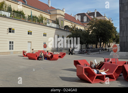 Persone che si rilassano all'aperto con i cosiddetti Enzis (mobili da salotto all'aperto) nel quartiere Museums Quartier nel centro di Vienna, Austria Foto Stock
