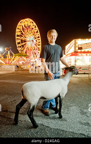 Ragazzo con una pecora e il parco dei divertimenti di corse al Maryland State Fair, Timonium MD Foto Stock