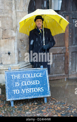 Cambridge Regno Unito 14 gennaio 2013. Facchini riparo dalla neve sotto gli ombrelli al di fuori del Trinity College di Cambridge. Neve spessa caduto durante il pomeriggio in East Anglia dopo una leggera spolverata per tutta la notte. Inoltre il freddo e la neve doccia sono le previsioni per i prossimi due giorni. Foto Stock