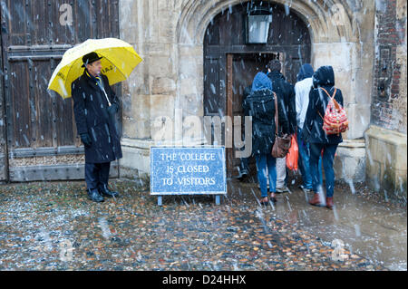 Cambridge Regno Unito 14 gennaio 2013. Facchini riparo dalla neve sotto gli ombrelli al di fuori del Trinity College di Cambridge. Neve spessa caduto durante il pomeriggio in East Anglia dopo una leggera spolverata per tutta la notte. Inoltre il freddo e la neve doccia sono le previsioni per i prossimi due giorni. Foto Stock