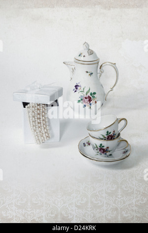 Vintage due tazze di caffè, una caffettiera e un presente scatola con una collana di perle Foto Stock