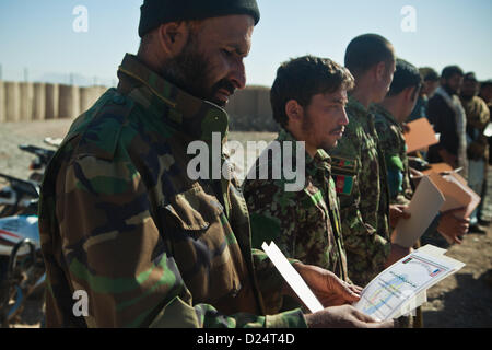 Esercito Nazionale Afghano soldati, polizia nazionale afgana, afgano e le forze di polizia locali guardare i loro certificati di completamento dopo quattro giorni di contro-improvvisato dispositivo esplosivo formazione nella provincia di Farah, Afghanistan, 14 gennaio 2013. Forze di sicurezza nazionali afgane sono state prendendo il filo nelle operazioni di protezione, con le forze della coalizione hanno come guide, per portare la sicurezza e la stabilità al popolo della Repubblica islamica dell'Afghanistan. (U.S. Marine Corps foto di Sgt. Pete Thibodeau/rilasciato) Foto Stock