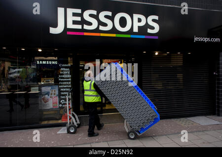 Londra, Regno Unito. Il 15 gennaio 2013. Un operaio ruote in scatole da imballaggio nell'Oxford Street negozio di fotografia rivenditore Jessops. Poste in amministrazione dai suoi proprietari, high-street ramo della catena britannica di fotografico merci e apparecchiature e il personale sono occupati dietro le persiane imballaggio i beni della società e le scorte di magazzino per essere venduto altrove. Jessops chiudere tutte le porte dei suoi 187 negozi del Regno Unito, risultante nella perdita di circa 1,370 posti di lavoro, per l'ultima volta. Fondata a Leicester in 1935 da Frank Jessop, è stato colpito negli ultimi anni da un aumento della concorrenza da supermercati e rivenditori di internet. Foto Stock