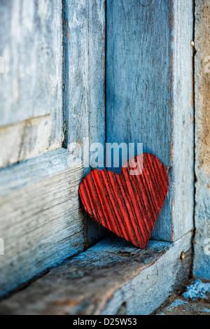 Red buccia di cocco corteccia forma di cuore su un vecchio vestito di stracci dipinte di blu porta. India Foto Stock