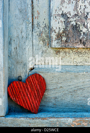 Red buccia di cocco corteccia forma di cuore su un vecchio vestito di stracci dipinte di blu porta. India Foto Stock