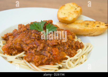 Gustosa cercando spaghetti bolognese servita con pane all'aglio. Foto Stock