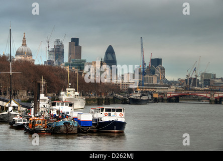 La città di Londra, visto dietro le barche sul Fiume Tamigi Foto Stock