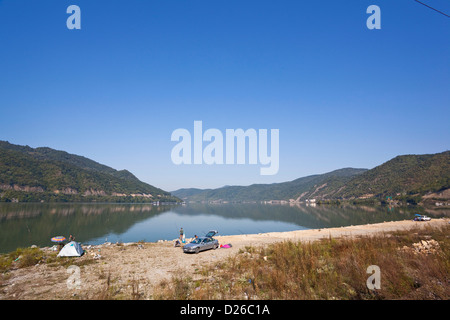 Cancello di ferro, Portile de Fier. Il Danubio downriver del villaggio di Berzasca, i turisti sono da campeggio e la pesca. La Romania Foto Stock