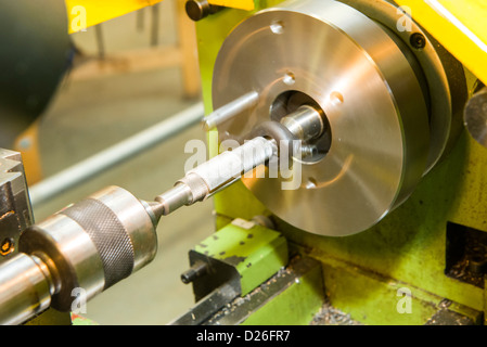 Un go-no-go calibro essendo acceso un metallo industriale tornio tra centri utilizzando una piastra di faccia e guidare il cane. Foto Stock