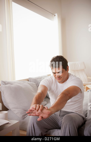 Giovane uomo stretching dopo il risveglio Foto Stock