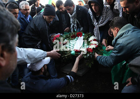 Gen 15, 2013 - Ramallah, West Bank, Territorio palestinese - palestinesi portano il corpo del 17 enne Samir Awad durante il suo funerale in Cisgiordania villaggio di Budrus vicino a Ramallah, martedì, Jan 15, 2013. I militari israeliani shot Awad morto vicino a West Bank barriera di separazione il Martedì, palestinesi detto. L'esercito israeliano ha detto di aver violato la barriera che separa i soldati da manifestanti (credito Immagine: © Issam Rimawi APA/images/ZUMAPRESS.com) Foto Stock