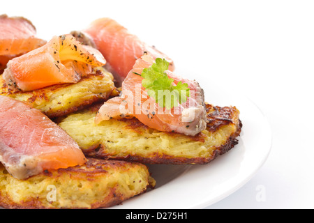 Fritti frittelle di patate con salmone salato su sfondo bianco Foto Stock