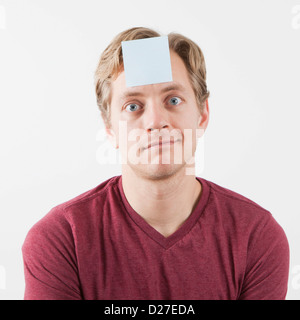 Uomo con adesivo nota sulla sua fronte Foto Stock