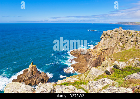 La signora irlandese roccia sotto Mayon cliff Pedn-uomini-du headland guardia costiera e lookout nella distanza Sennen Cove Cornwall Regno Unito Foto Stock