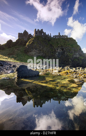 Il famoso Dunluce Castle - una pietra miliare dell'UNESCO da Causeway costa dell'Irlanda del Nord - riflessa in un pool di marea dalla spiaggia Foto Stock