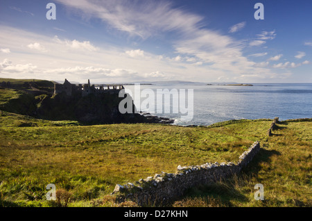 Dunluce Castle in cima a una scogliera - un famoso punto di riferimento dalla costa dell'Irlanda del Nord - su un bel pomeriggio di sole. Foto Stock