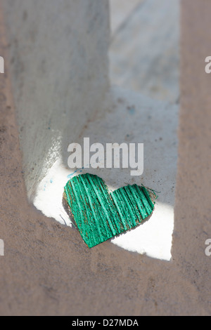 Verde buccia di cocco corteccia forma di cuore su una casa bianca balaustra. India Foto Stock