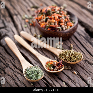 Varietà di spezie in cucchiai su un vecchio tavolo di legno. Foto Stock