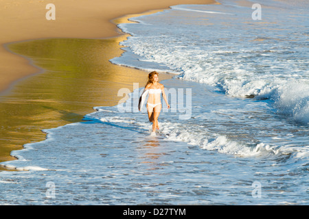 Donna in corsa sulla spiaggia perfetta. Foto Stock