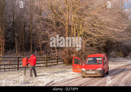 Southwold, Suffolk, Regno Unito. 16 gennaio 2013. Un Royal Mail portalettere fuori alla consegna si svuota una casella postale nella neve come le temperature nella zona raggiungere -10 gradi. Benacre , vicino a Southwold , Suffolk , Inghilterra , Inghilterra , REGNO UNITO Foto Stock