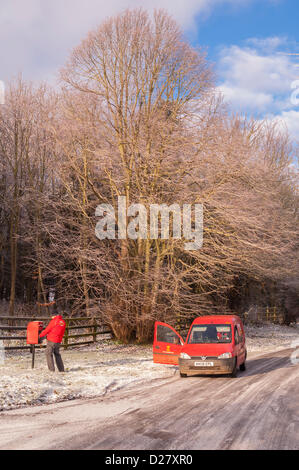 Southwold, Suffolk, Regno Unito. 16 gennaio 2013. Un Royal Mail portalettere fuori alla consegna si svuota una casella postale nella neve come le temperature nella zona raggiungere -10 gradi. Benacre , vicino a Southwold , Suffolk , Inghilterra , Inghilterra , REGNO UNITO Foto Stock