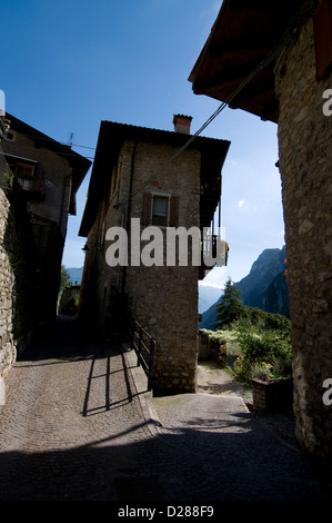 Il villaggio rurale medievale di ‘Tenno’, deformato nel tempo e ben conservato, con un castello privato di origine medievale nei dintorni Foto Stock