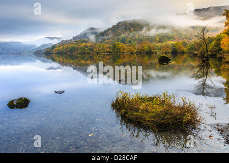 Ullswater nel Parco nazionale del Lake District catturati durante un breve periodo di debole luce del sole su una mattina atmosferica nel mese di ottobre Foto Stock