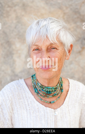 Ritratto di una bella e graziosa senior donna che indossa gioielli di arte medicina complemento. Foto Stock