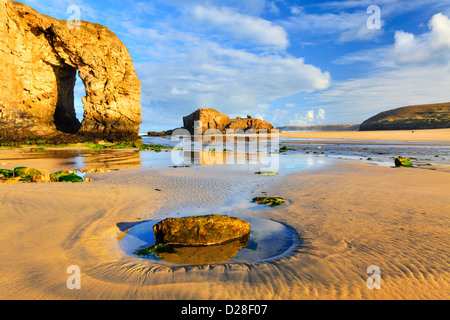 La luce del mattino sull arco sulla spiaggia a Perranporth Foto Stock