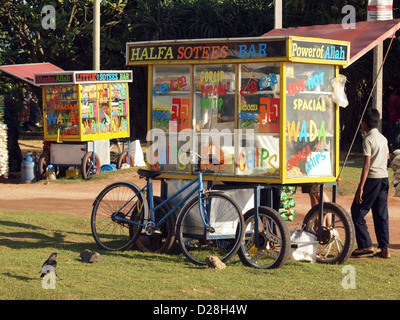 Decorate luminosamente il fast food i carrelli con operatore crow e bicicletta sulla spiaggia a Negombo Sri Lanka nella luce della sera Foto Stock